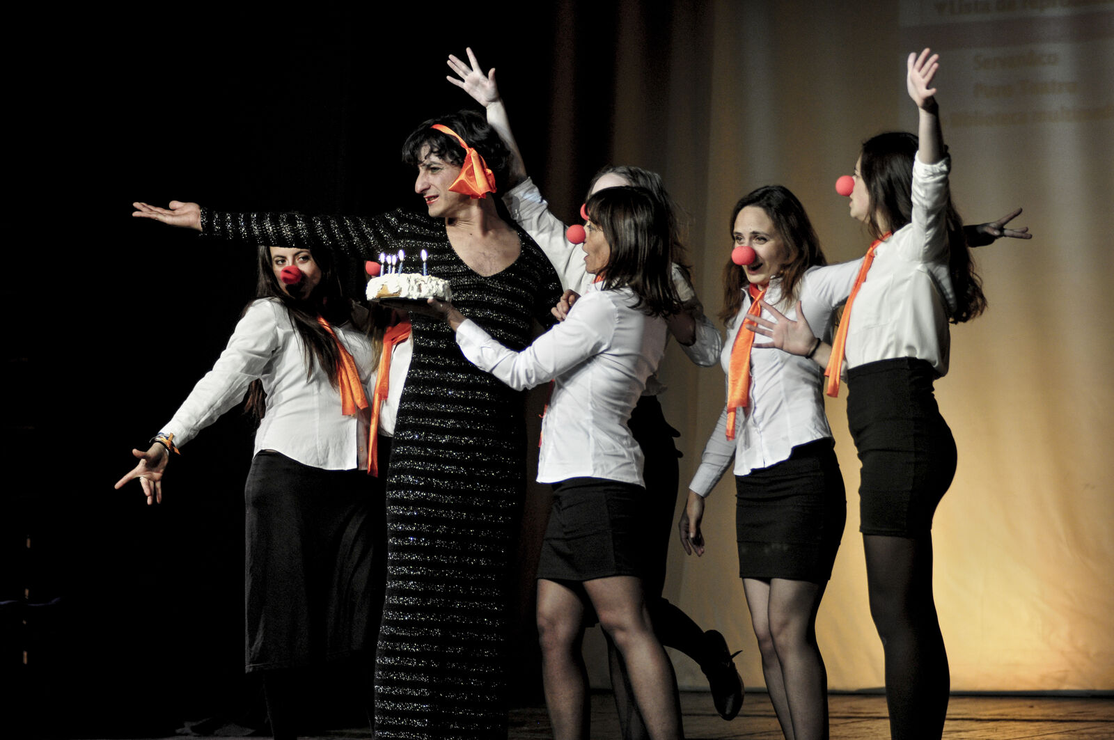 Grup d'adults amb nassos de clown saludant al final d'una mostra